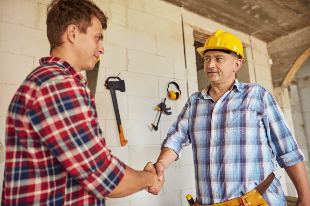 Deux homme sur un chantier se serrent la main