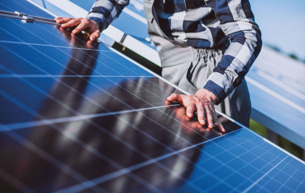 Un technicien de SIME installant des panneaux solaires